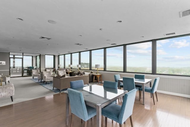 dining area with light wood-type flooring and baseboards
