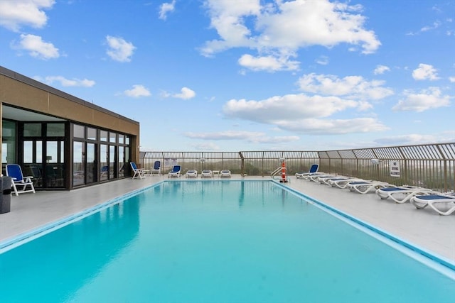 community pool with a patio and fence