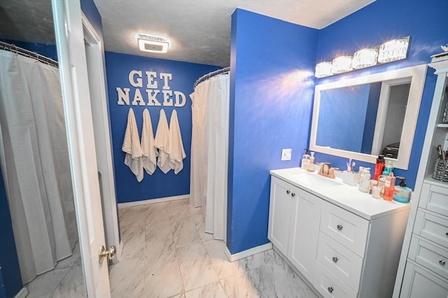 bathroom with marble finish floor, baseboards, and vanity