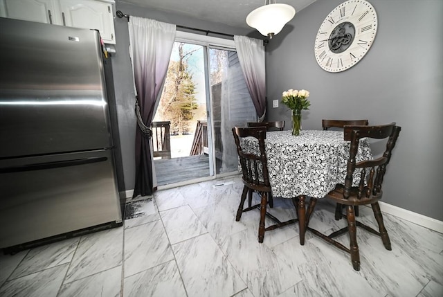 dining room with marble finish floor and baseboards