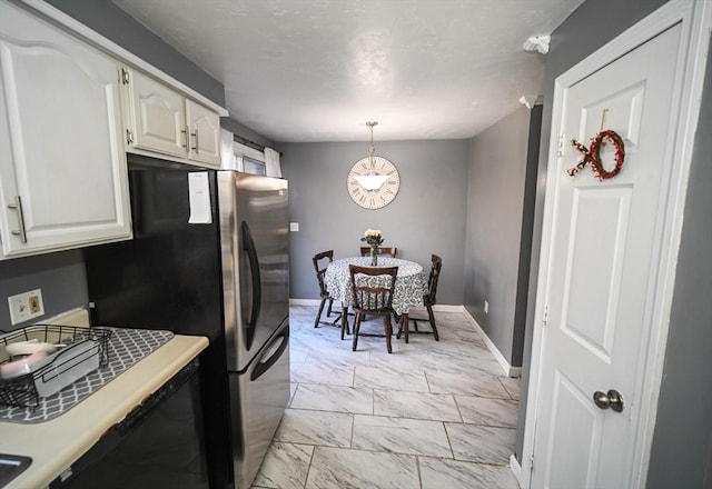 kitchen featuring baseboards, white cabinets, marble finish floor, light countertops, and pendant lighting