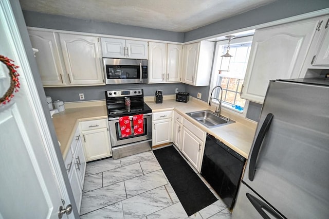 kitchen featuring stainless steel appliances, marble finish floor, white cabinets, and a sink