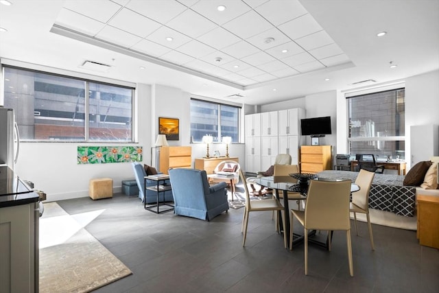 dining room featuring a wealth of natural light, a raised ceiling, and recessed lighting