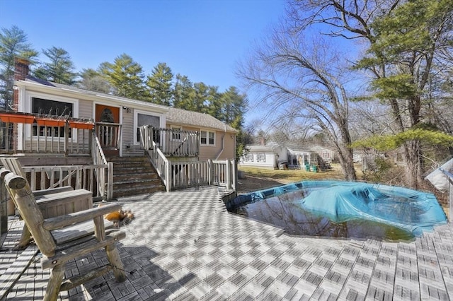 view of pool featuring a covered pool, a deck, and stairway