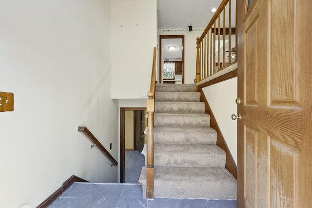 staircase featuring baseboards