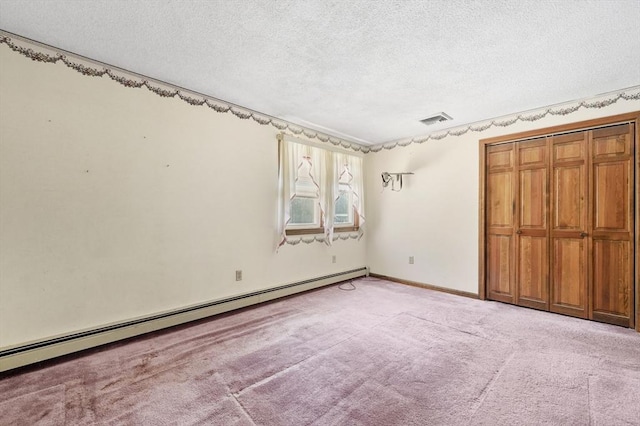 unfurnished bedroom with visible vents, light carpet, a textured ceiling, a closet, and baseboard heating