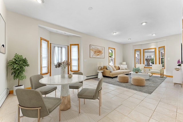 living room featuring a baseboard heating unit, a wealth of natural light, and light tile patterned floors