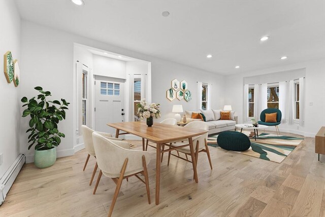 unfurnished living room with a baseboard heating unit and light tile patterned floors