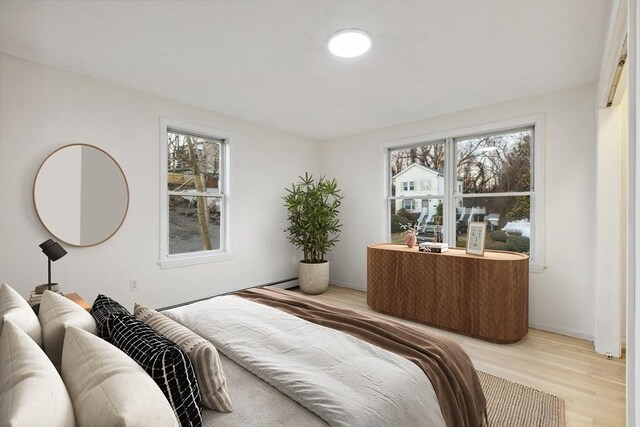 bedroom featuring multiple windows and wood finished floors