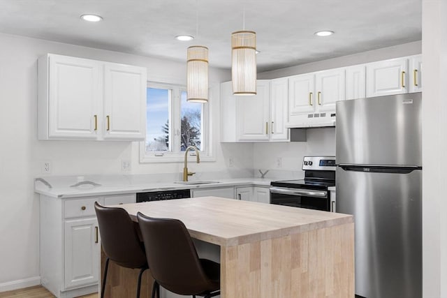 kitchen with under cabinet range hood, a kitchen island, a sink, white cabinets, and appliances with stainless steel finishes