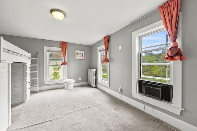 bathroom featuring radiator, baseboards, plenty of natural light, and cooling unit