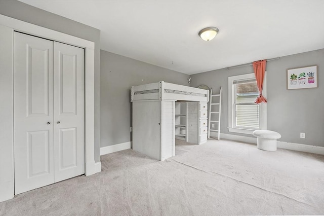 unfurnished bedroom featuring carpet, baseboards, and a closet