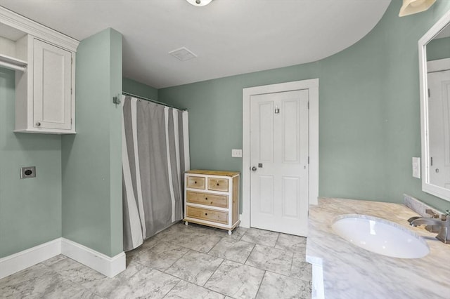 full bathroom with marble finish flooring, vanity, baseboards, and a shower with curtain