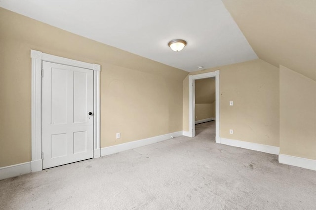 additional living space featuring carpet floors, vaulted ceiling, and baseboards