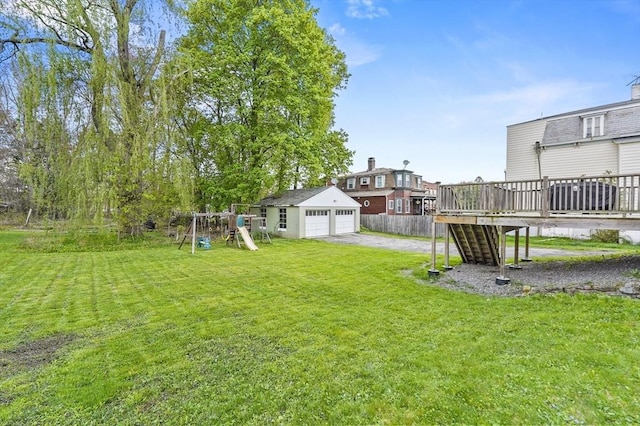 view of yard featuring a playground, a deck, an outbuilding, a garage, and stairs