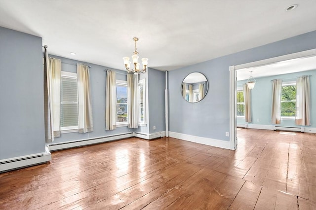 unfurnished dining area with a chandelier, a baseboard heating unit, wood-type flooring, and recessed lighting