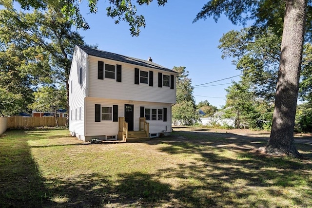 back of house with fence and a lawn
