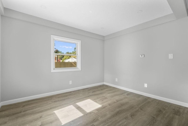 unfurnished room with baseboards and wood finished floors