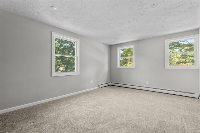 carpeted empty room featuring baseboards, a textured ceiling, and baseboard heating