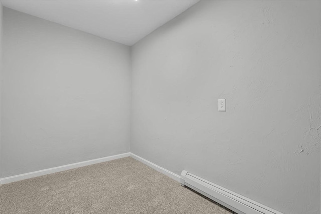 unfurnished room featuring a baseboard heating unit, baseboards, and carpet floors
