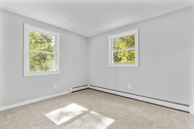 carpeted spare room with plenty of natural light, a baseboard radiator, and baseboards