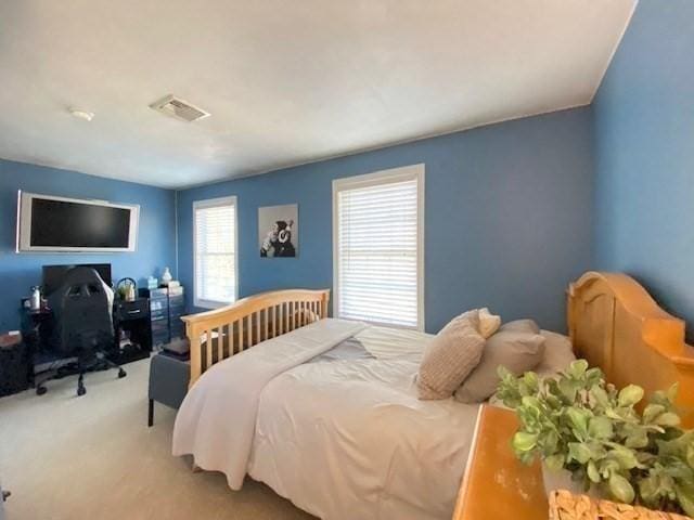 carpeted bedroom featuring visible vents