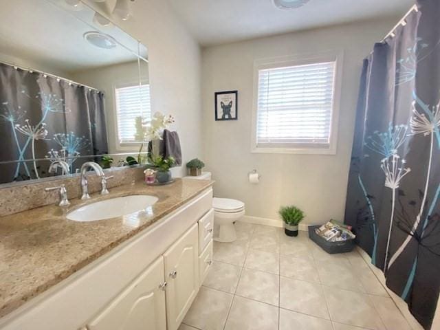 bathroom featuring plenty of natural light, vanity, toilet, and tile patterned floors