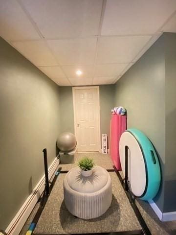 interior space with a baseboard radiator, a paneled ceiling, and baseboards