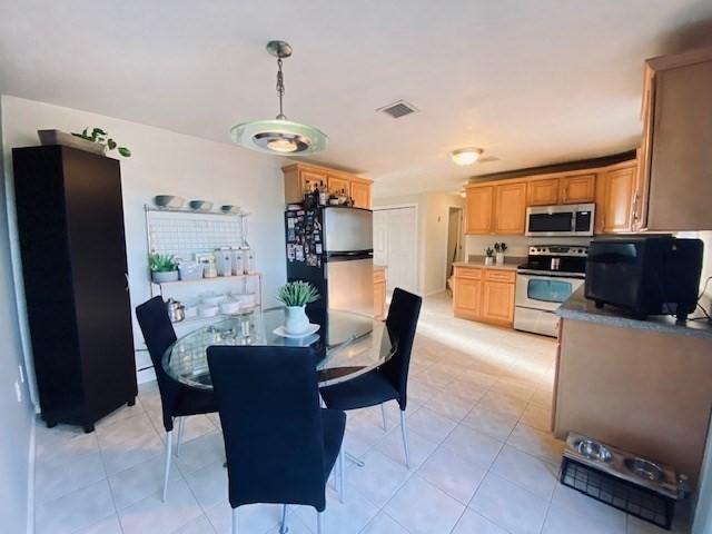 dining area with light tile patterned flooring and visible vents