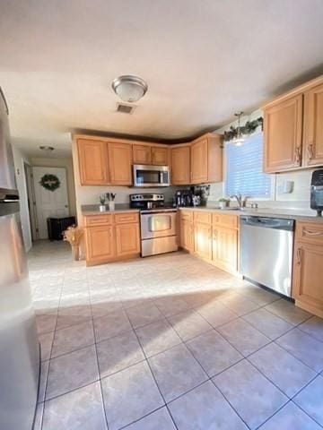 kitchen featuring visible vents, appliances with stainless steel finishes, light countertops, a sink, and light tile patterned flooring