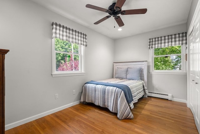 bedroom featuring baseboard heating, multiple windows, baseboards, and recessed lighting