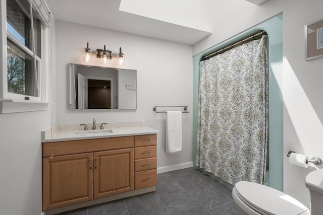 bathroom with toilet, vanity, baseboards, and a shower with curtain