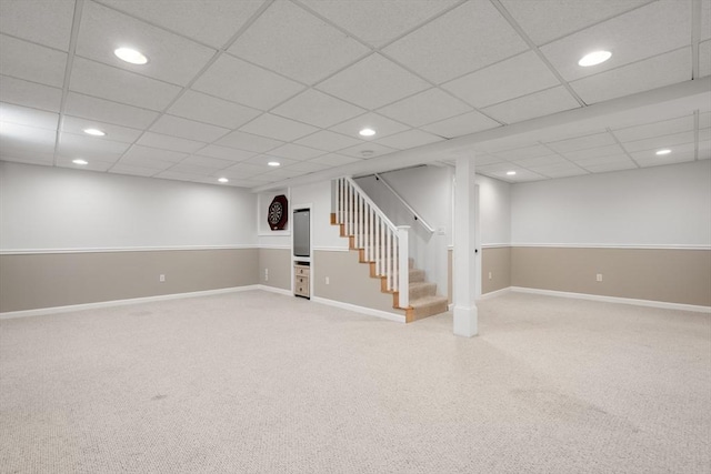 finished below grade area with light colored carpet, stairway, recessed lighting, baseboards, and a paneled ceiling