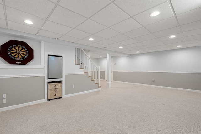 finished basement featuring carpet flooring, stairway, recessed lighting, baseboards, and a paneled ceiling