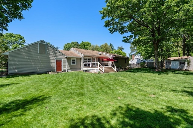 back of property featuring a storage shed, an outbuilding, and a deck