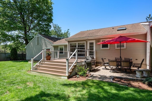 back of property featuring a wooden deck, a patio, and a shingled roof