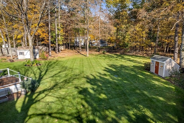 view of grassy yard with a storage unit, an outdoor structure, and view of scattered trees