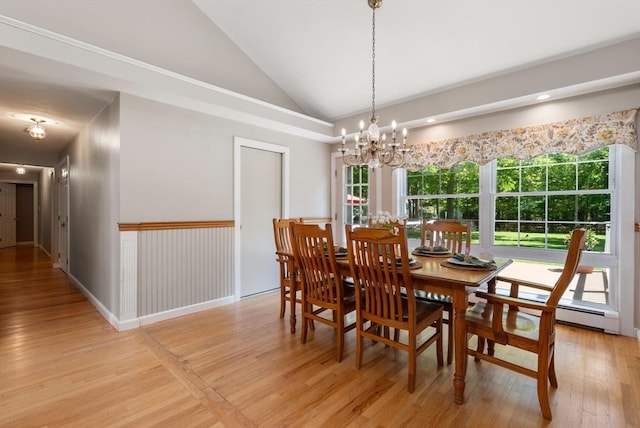 dining room with lofted ceiling, light wood-type flooring, and a chandelier