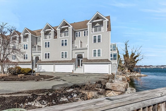 view of front of home featuring a garage, driveway, and a water view