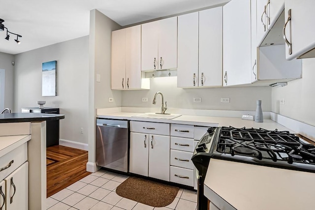 kitchen with light tile patterned floors, a sink, black gas stove, white cabinetry, and dishwasher