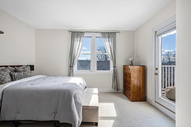 bedroom with access to exterior, light carpet, and baseboards