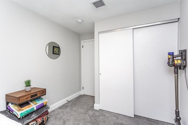 interior space featuring light colored carpet and a closet