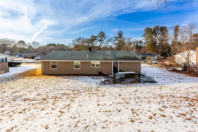 view of snow covered rear of property