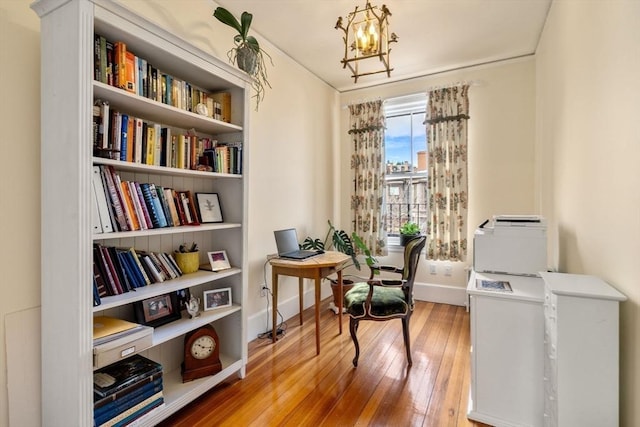 office featuring an inviting chandelier, wood-type flooring, and baseboards