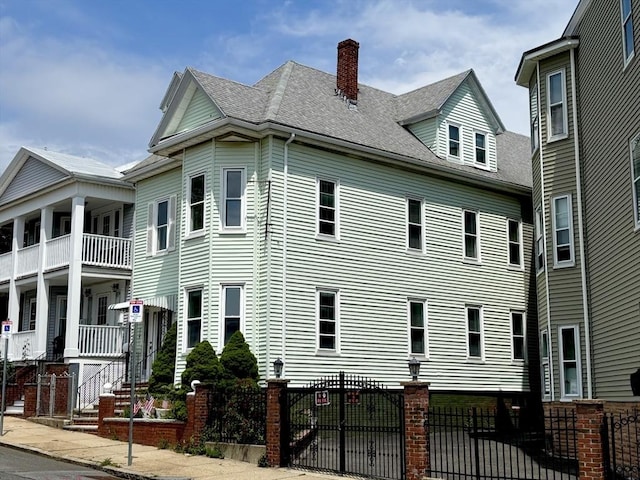 114 Byron St, Boston, MA 02128 - view of property exterior featuring a shingled roof, a fenced front yard, and a chimney