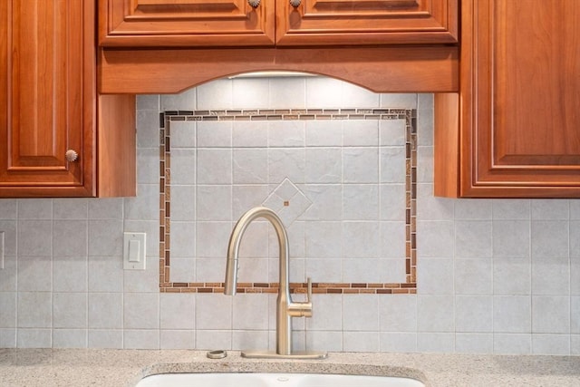 114 Byron St, Boston, MA 02128 - kitchen view of a sink, decorative backsplash, light stone counters, and brown cabinets