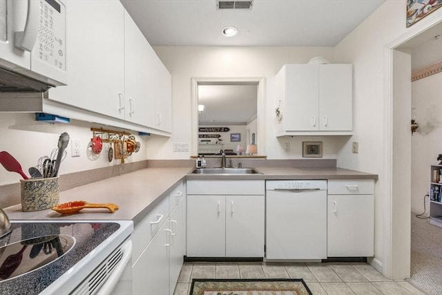 kitchen featuring white cabinetry, sink, light colored carpet, and white appliances