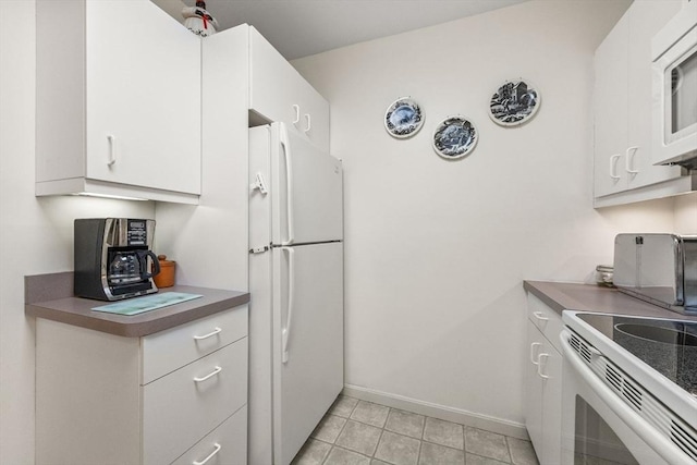 kitchen featuring light tile patterned floors, white appliances, and white cabinetry