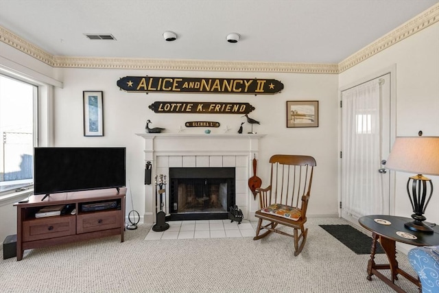 living area featuring ornamental molding, a tile fireplace, and light carpet