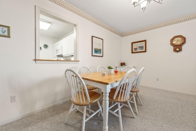 carpeted dining area featuring ornamental molding